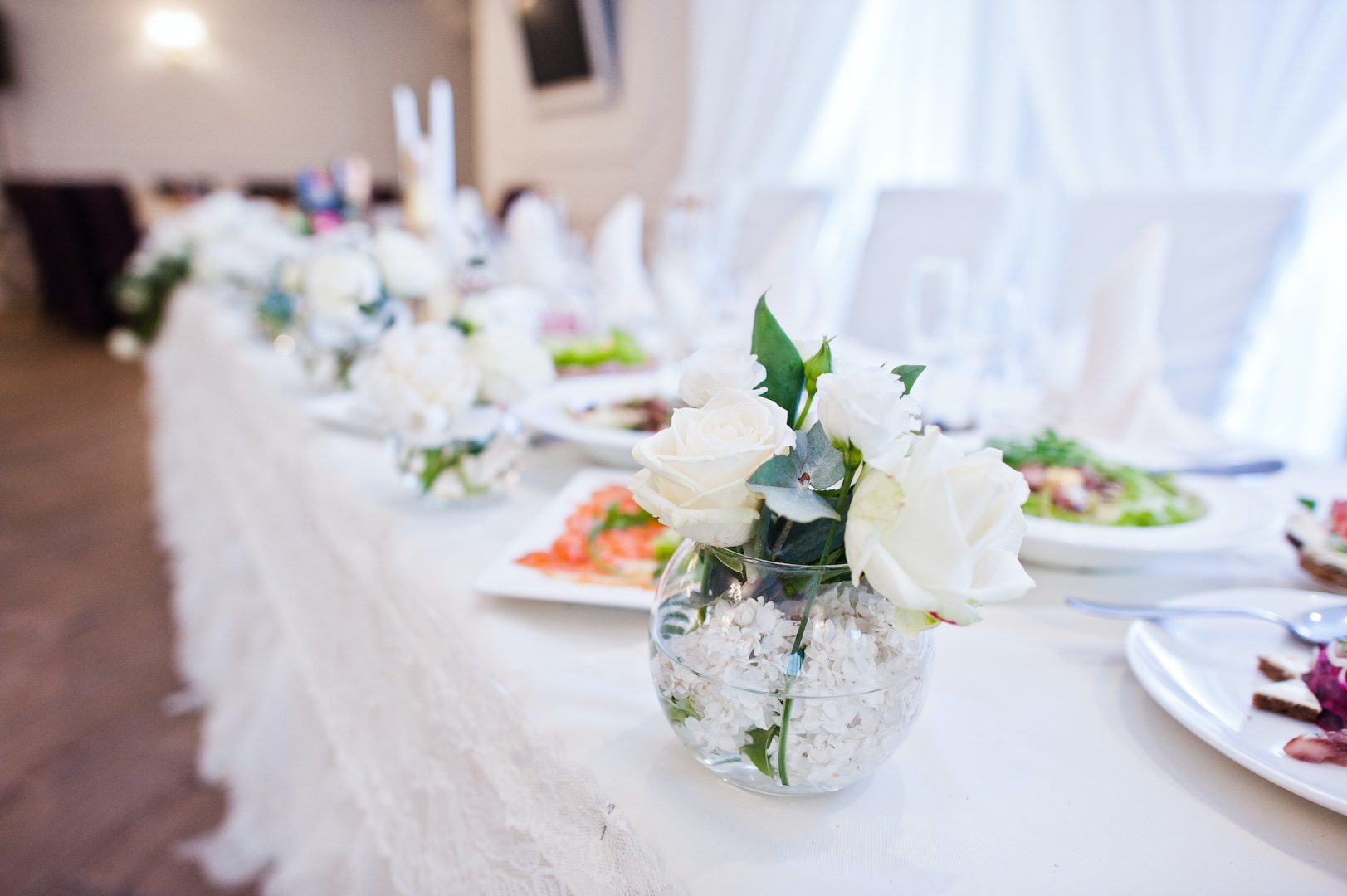 Flowers decor on table of newlyweds at wedding hall.